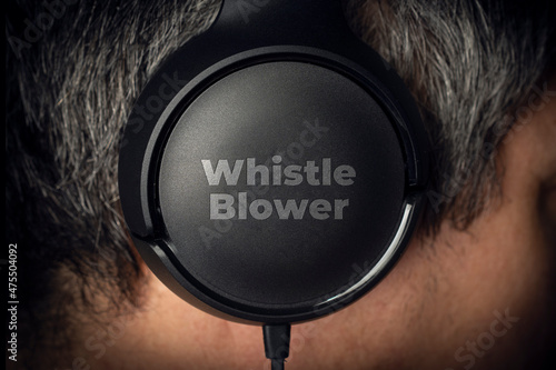 Whistleblower concept: a mystery man wear a pair of headphone with the  engraved text: wistle blower photo