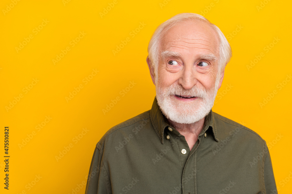 Photo of cute aged beard man look promo wear khaki shirt isolated on yellow color background Photo of cute aged beard man look promo wear khaki shirt isolated on yellow color background