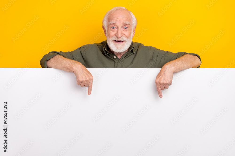Photo of cute old beard man index placard wear khaki outfit isolated on yellow color background Photo of cute old beard man index placard wear khaki outfit isolated on yellow color background