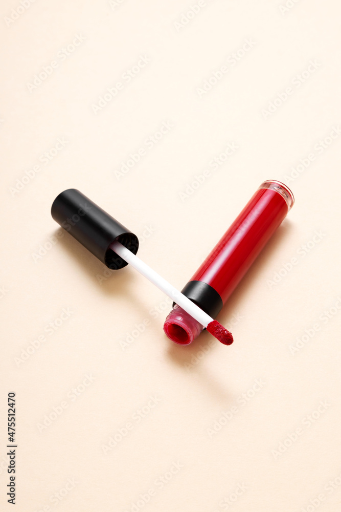 Open tube red lipstick and applicator wand on beige background. Makeup cosmetic product Open tube red lipstick and applicator wand on beige background. Makeup cosmetic product