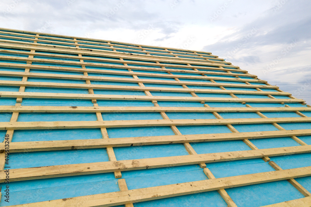 Obraz premium Brick house with wooden roof frame under construction.