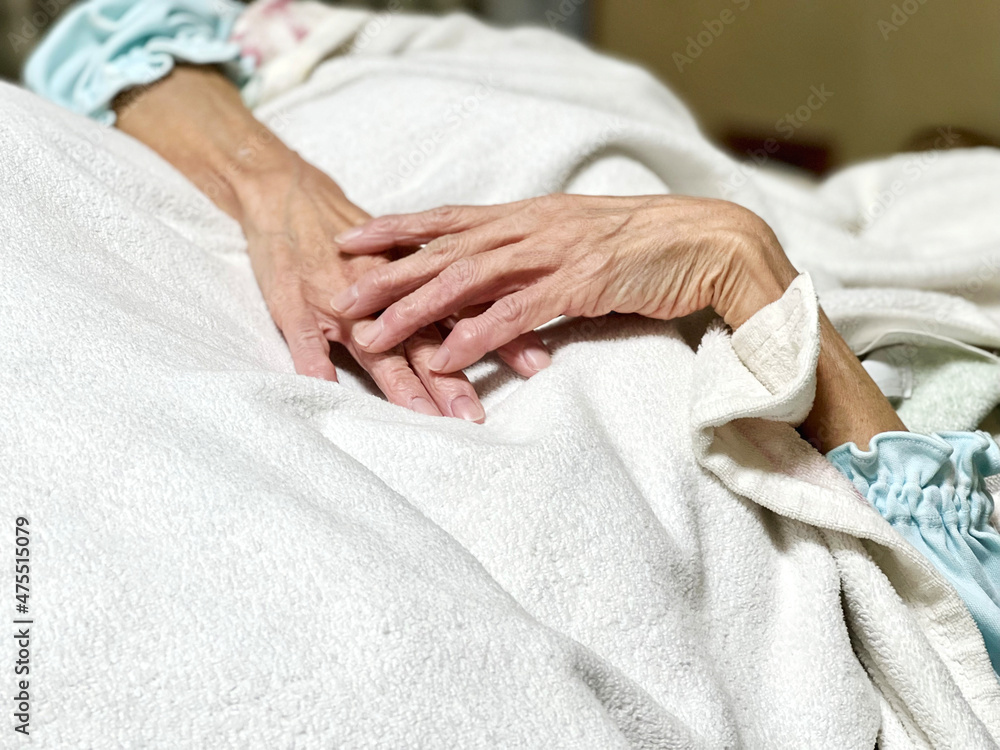 白い毛布をかけて寝る高齢女性の手 Stock Photo Adobe Stock