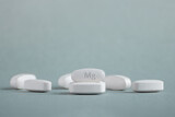 Tablets , vitamins with the abbreviation Mg ( magnesia, macro element magnesium ) on a light background. Copy space.