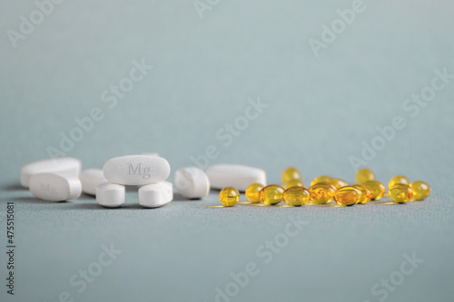 Canvas Print A complex of Mg ( magnesia, magnesium ) and vitamin D ( omega 3 ) capsules for treatment and human health on a light background