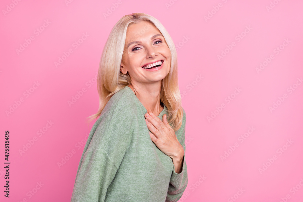 Profile photo of cool elder blond lady hand brest wear grey pullover isolated over pink color background Profile photo of cool elder blond lady hand brest wear grey pullover isolated over pink color background