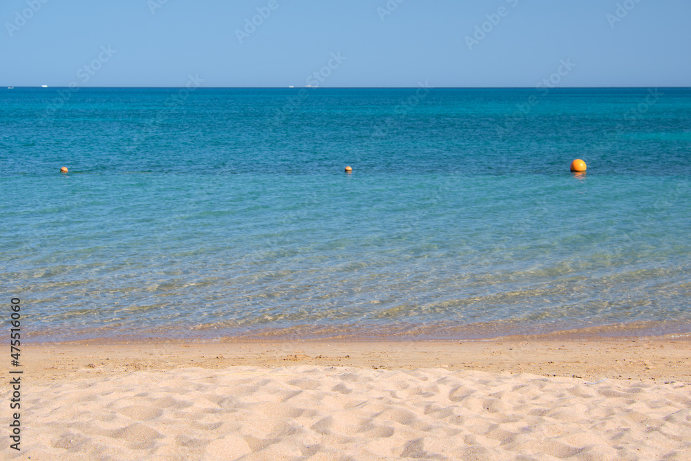 Seascape with surface of blue sea water with small ripple waves crashing on yellow sandy beach. Travel and vacations concept Seascape with surface of blue sea water with small ripple waves crashing on yellow sandy beach. Travel and vacations concept
