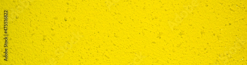 light yellow concrete texture. pattern on wall. yellow plaster with black dots. banner for placement on site