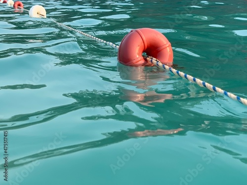 Beach buoys on a rope in the sea. A marker for swimming in blue water. Concept: swimming in the warm sea, water sports. Swimming lane in the pool.