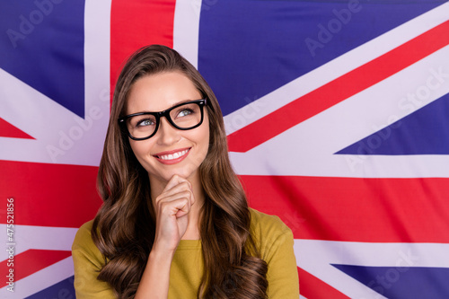 Photo of pretty cheerful lady hand on chin look curious copyspace isolated on british flag background