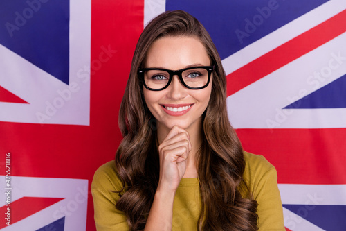 Portrait of minded smart person arm on chin toothy smile wear yellow isolated on british flag background