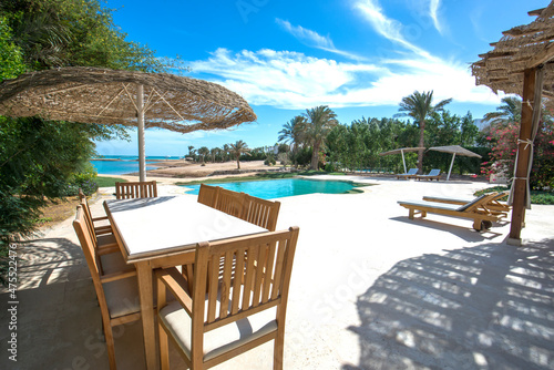 Swimming pool and outdoor dining area at at luxury tropical holiday villa resort © Paul Vinten