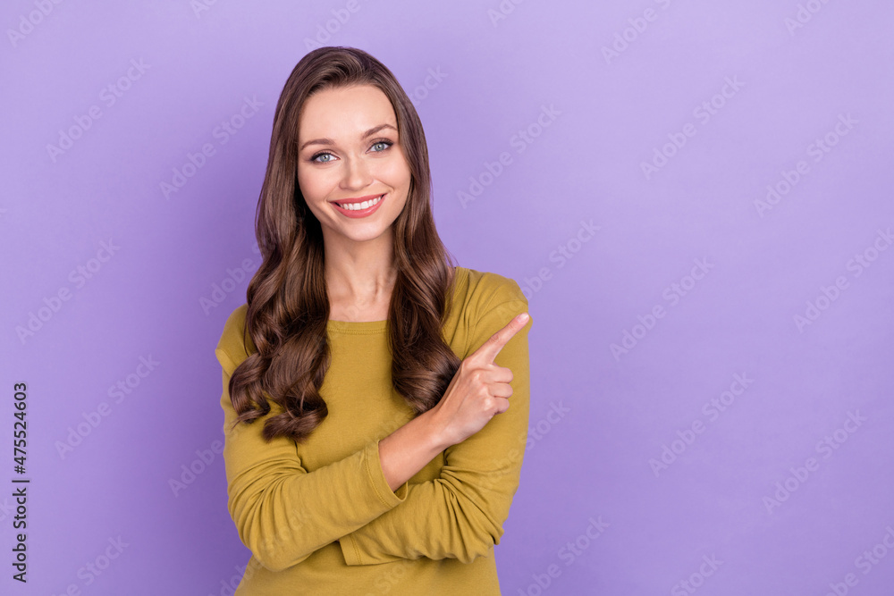 Fototapeta premium Photo of charming cheerful lady direct finger empty space proposition beaming smile isolated on violet color background