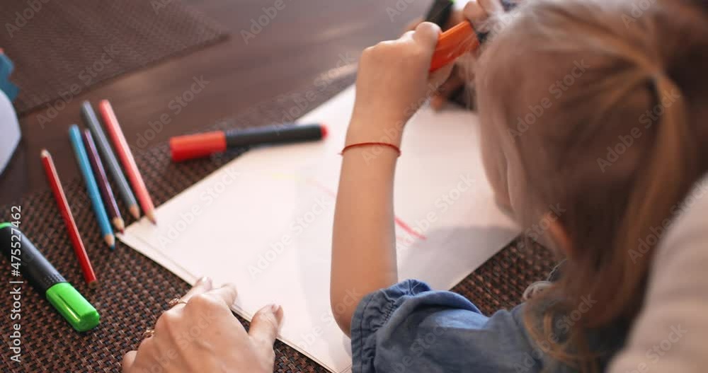 A young mother and daughter are drawing in a cafe, waiting for an order. Motherhood. Happy family in a cafe. A young mother and daughter are drawing in a cafe, waiting for an order. Motherhood. Happy family in a cafe.