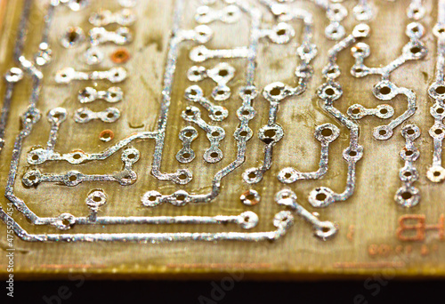 Printed yellow circuit board close-up. Electronic computer hardware technology macro photo. A digital motherboard chip. Microprocessor, transistors, semiconductor made from silicon. Technical science.
