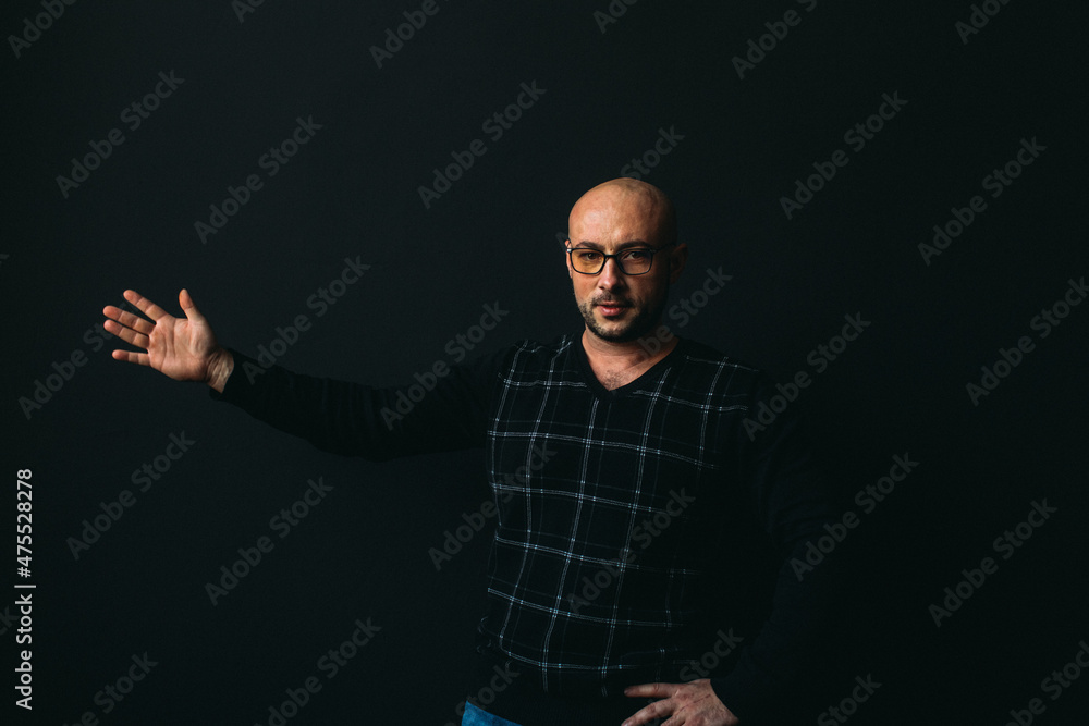 a young man, businesslike, sociable speaker, says something with gestures. in the studio on a black background. a young man, businesslike, sociable speaker, says something with gestures. in the studio on a black background.