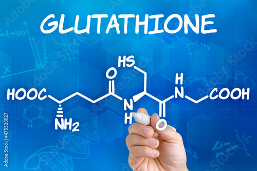 Hand with pen drawing the chemical formula of Glutathione photo