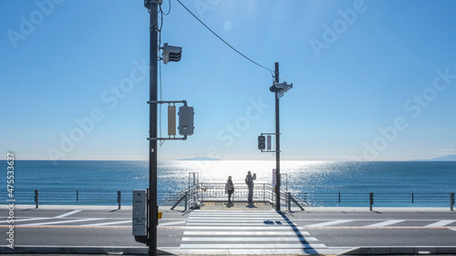 Couple taking photo by the seaside in front of the traffic lamps in Japan