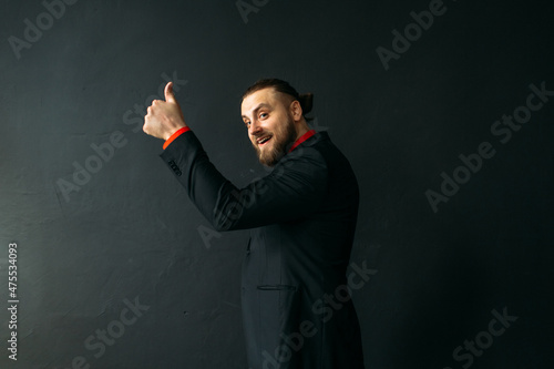 young man, business, sociable speaker, businessman, in a suit with a red shirt, in the studio on a black background.