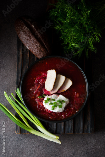 Traditional Ukrainian cuisine - borscht with sour cream and green onions