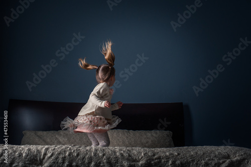 A Young Girl Lady Jumping Playing on the Bed with Pigtails and Hair Going Wild Childhood Unplugged Dress Fun Play Child Kid A Young Girl Lady Jumping Playing on the Bed with Pigtails and Hair Going Wi
