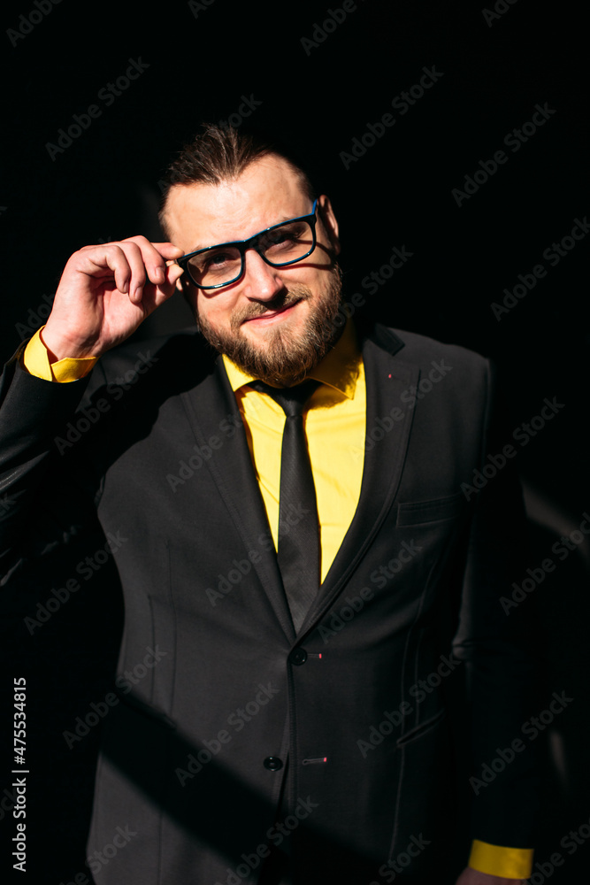 young man, business, sociable speaker, businessman, in a suit with a yellow shirt, in the studio on a black background. young man, business, sociable speaker, businessman, in a suit with a yellow shirt, in the studio on a black background.
