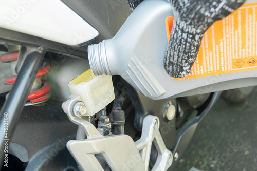 Motorcycle maintenance service, Close up of Auto mechanic pouring new motorcycle brake fluid.