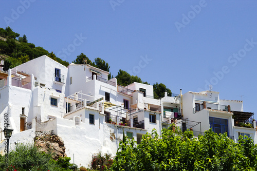 Beautiful Frigiliana village, Spain Whitewashed traditional houses on a steep hillside Dramatic landscape with view of the old town Blue sky and copy space