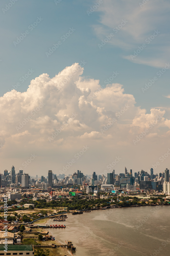 Obraz premium Bangkok, Thailand - May 13, 2021 : Beautiful sky and cloud view of Bangkok with skyscrapers along Chaopraya river in the afternoon. Selective focus.