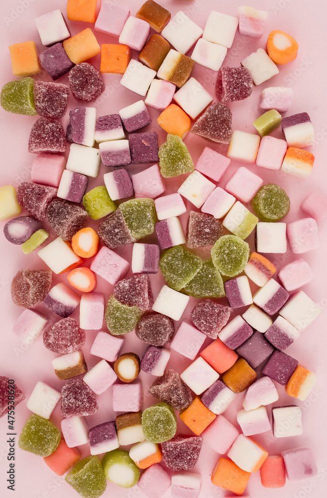 A large pile of mixed sweets on wooden background A large pile of mixed sweets on wooden background
