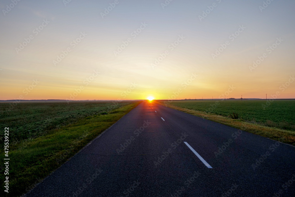 The road leading straight to the rising sun at dawn