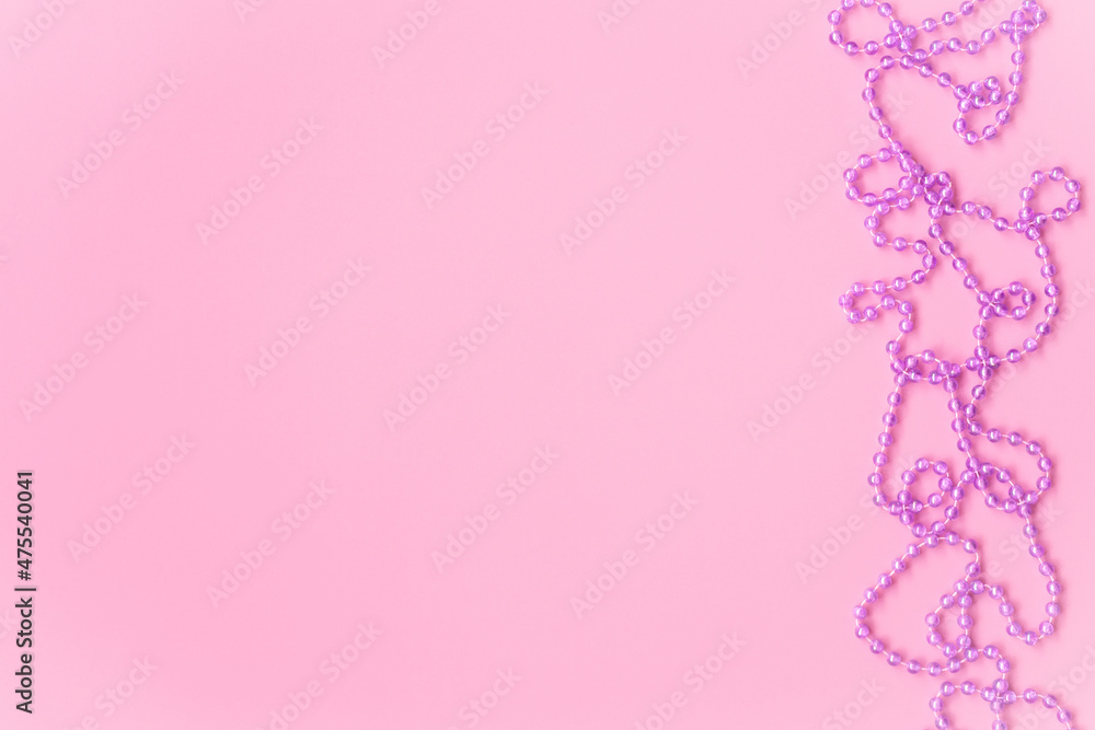 Xmas beads border decoration on trending pastel pink christmas background this space for your text. flat lay, top view, copy space