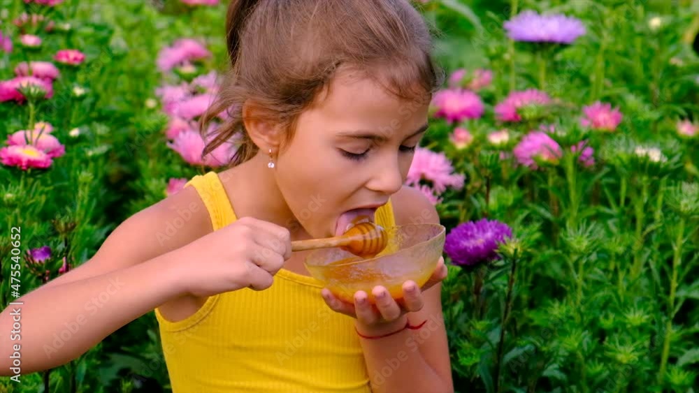 The child eats honey in the garden. Selective focus. The child eats honey in the garden. Selective focus.