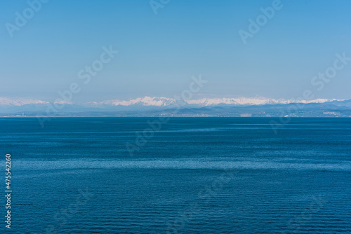 Blue seascape in minimalistic style with the mountains in the background in Piran, Slovenia