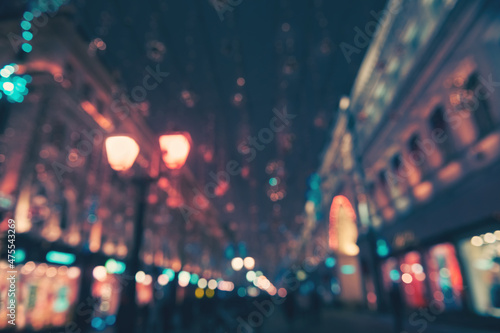 Blurred view of night street with Christmas decoration. Moscow, Russia. Abstract city night lights background. Glowing festive garlands and lights