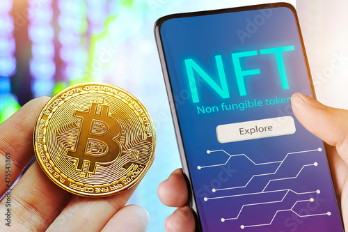 Hand holds smartphone with bitcoin cryptographic NFT blockchain marketplace,Cryptoart concept photo
