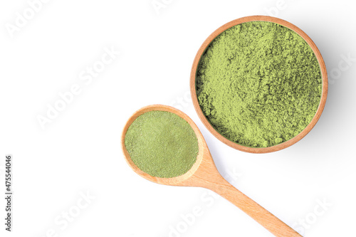 Green herbal powder in ceramics mortar and wooden spoon isolated on white background. Copy space.