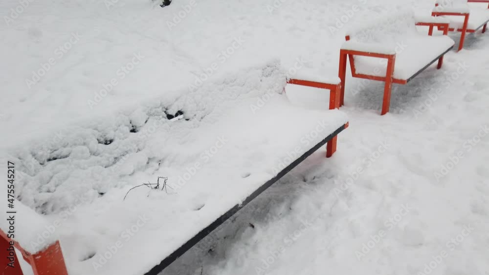 Snow covered benches in the winter park. Snow covered benches in the winter park.