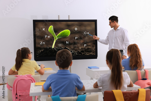 Teacher using interactive board in classroom during lesson photo