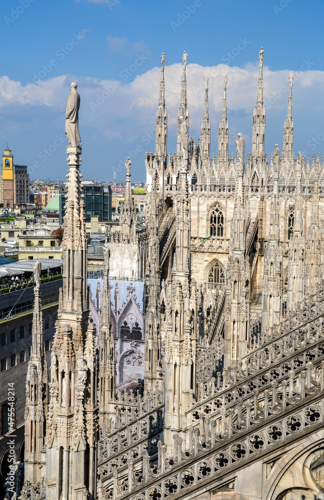 A view on the detailed of the Milan Cathedral Duomo di Milano with Gothic spires, marble statues and arches. The main tourist attraction of the Milan