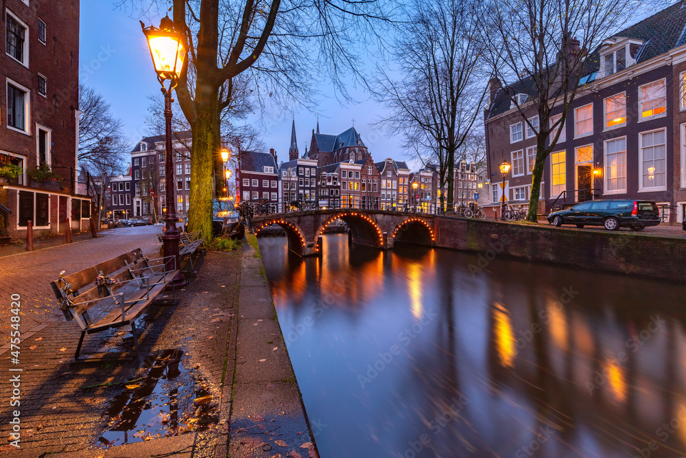 Amsterdam canal Leidsegracht with typical dutch houses and bridge during evening blue hour, Holland, Netherlands