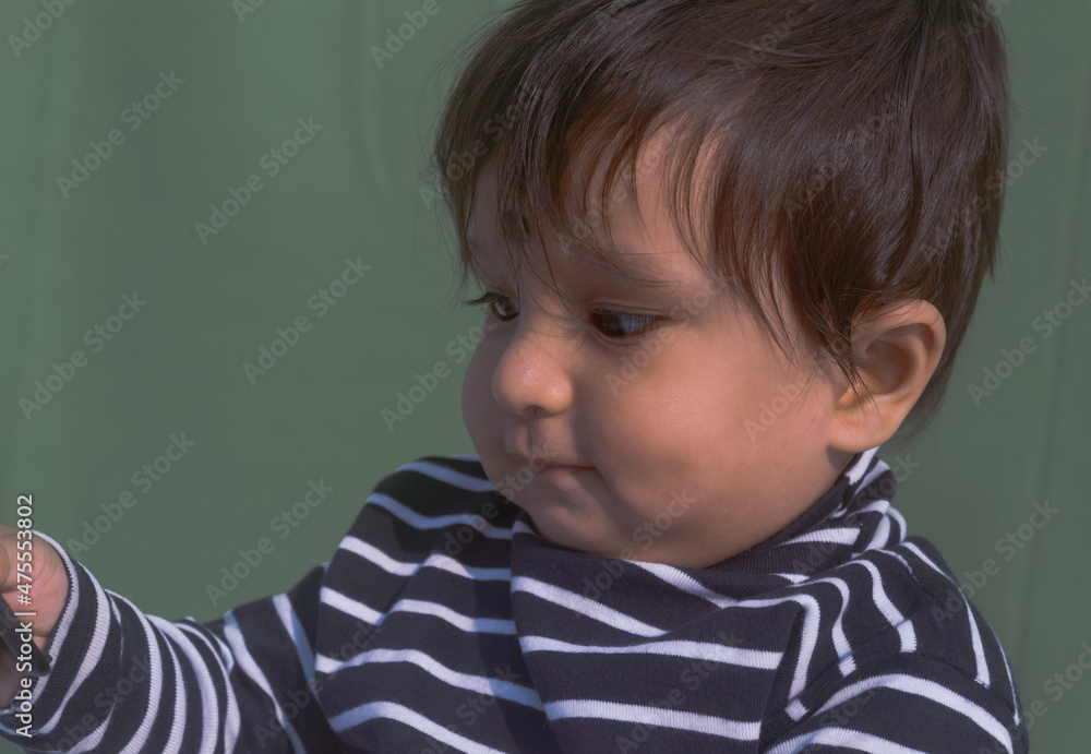 Baby looking at mobile phone. Sweet small baby with mobile phone on a isolated background. Head shot portrait. Front View. Close up. Indian ethnicity. Baby looking at mobile phone. Sweet small baby with mobile phone on a isolated background. Head shot portrait. Front View. Close up. Indian ethnicity.