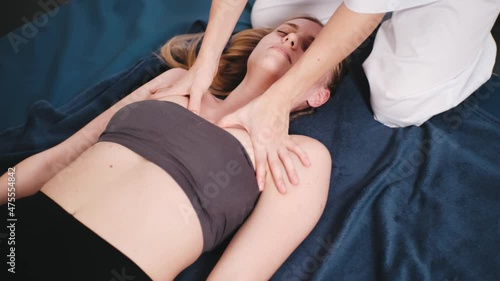 Masseur makes chinese massage of neck and decollete of woman in clinic