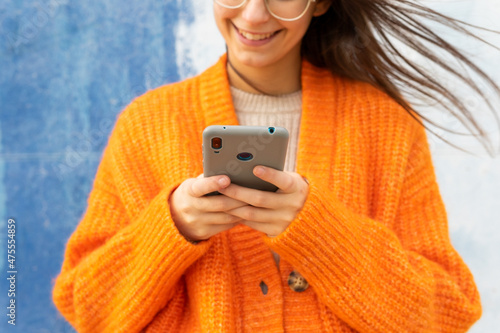 Anonymous woman in eyeglasses messaging on mobile phone photo