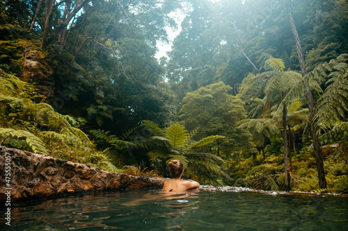 Anonymous man relaxing in tropical pool photo