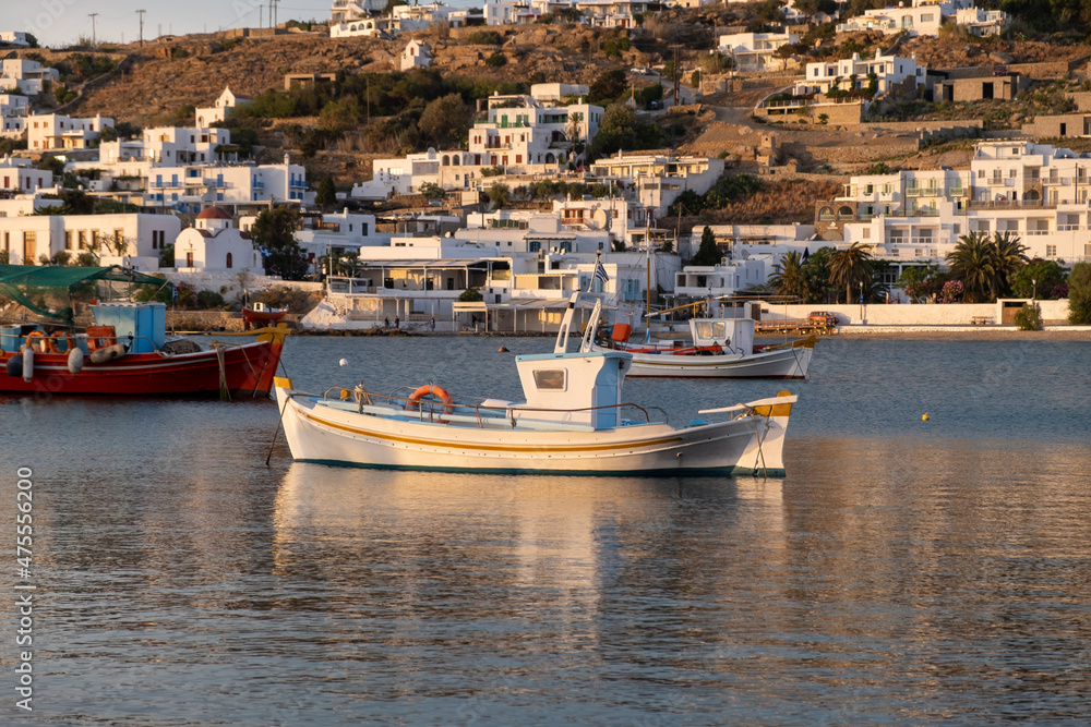 Greek fishing boat in Mykonos island old harbor, Chora town buildings background Cyclades, Greece