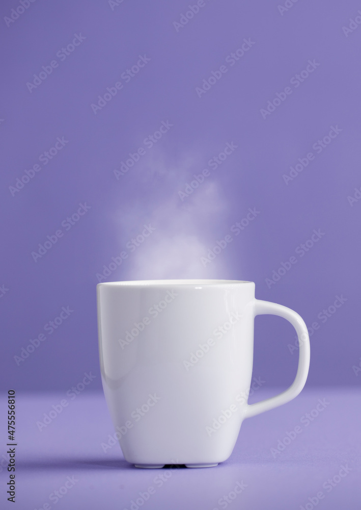 White ceramic cup of coffee or tea with hot steam, with a purple background (very peri). White ceramic cup of coffee or tea with hot steam, with a purple background (very peri).