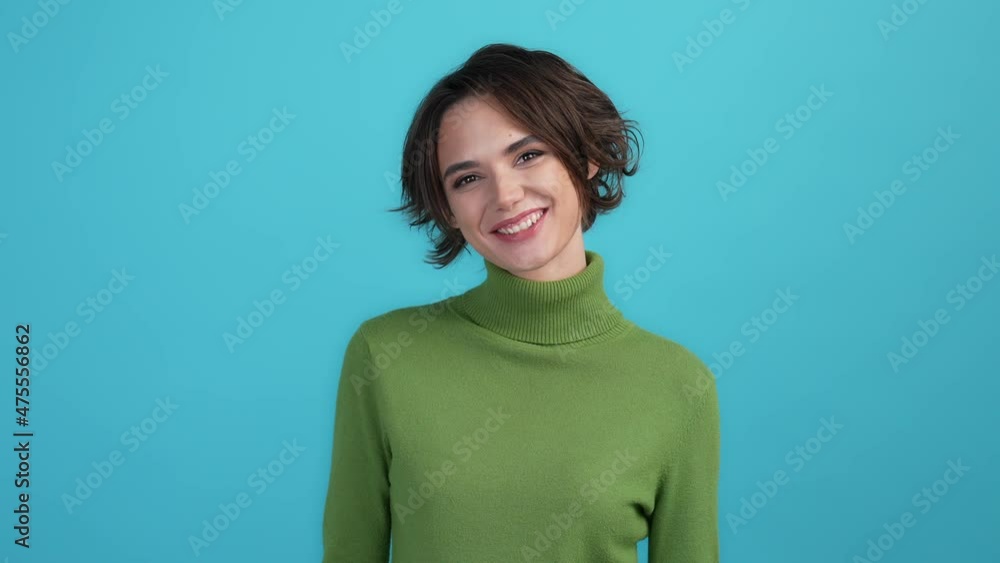 Adorable girlish lady smiling in camera isolated sky light color background