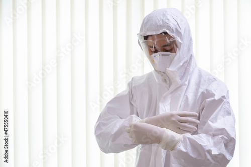 doctor wearing ppe suit and facemask perform coronavirus covid-19 PCR test. doctor puts on protective gloves and wearing ppe protection suit for fighting new omicron covid. selective focus. photo