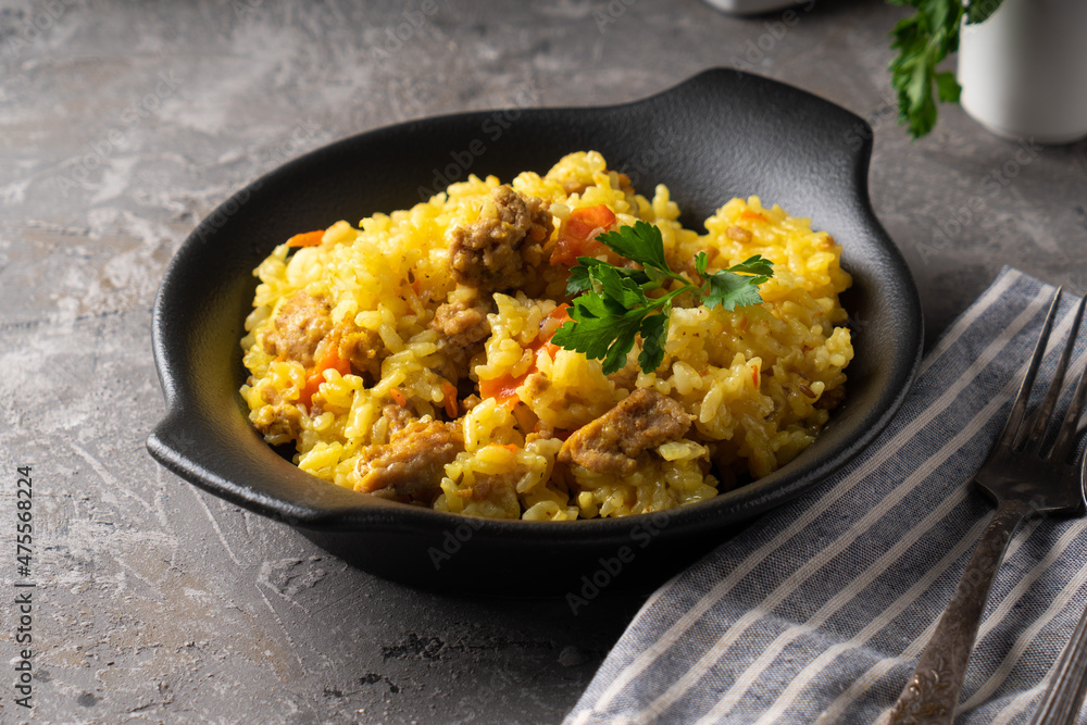 Traditional azian pilaf served in plate on gray background