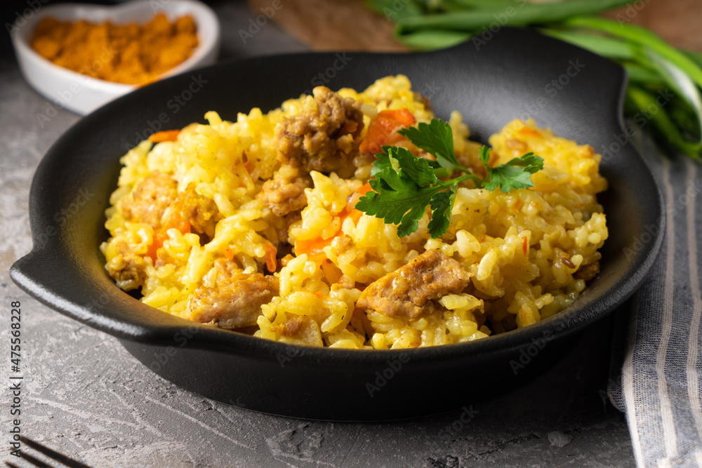 Traditional azian pilaf served in plate on gray background Traditional azian pilaf served in plate on gray background